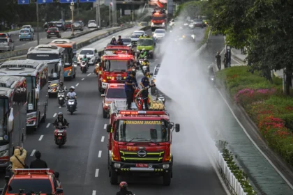 Petugas Dinas Penanggulangan Kebakaran dan Penyelamatan (Gulkarmat) DKI Jakarta menyemprotkan air di Jalan Jenderal Sudirman, Jakarta, Minggu (6/9/2026).