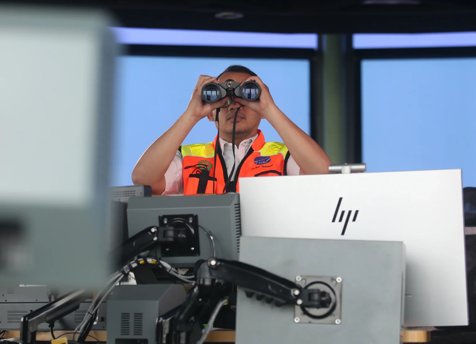 Petugas Air Traffic Control (ATC) dengan menggunakan binocular memantau aktivitas udara di Bandara Soekarno Hatta di Jakarta Air Traffic Control (JATC), Tangerang, Banten